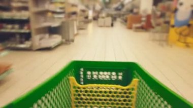 Yeşil sepeti ile alışveriş yürürken. Hızlı hareket.