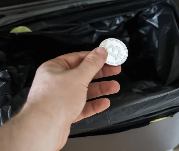 Man throws a bitcoin coin in the trash bin. — Stock Photo, Image