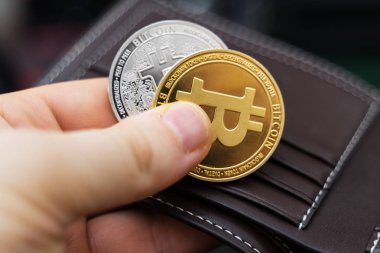 Fiziksel altın ve gümüş bitcoins sürümü tutan adam.