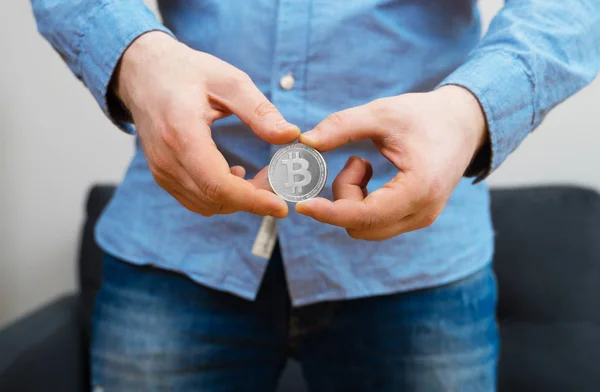 Hombre sosteniendo bitcoin físico de plata. Símbolo de la moneda virtual . —  Fotos de Stock