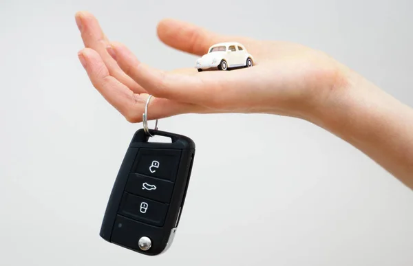 Mão segurando brinquedo de carro pequeno e chaves. Conceito de compra de carro . — Fotografia de Stock