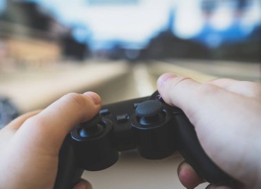 TV 'de yarış oyununu oynayan adam. gamepad denetleyicisi ellerde.