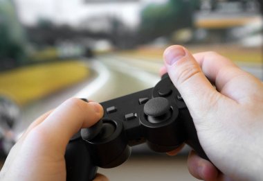 TV 'de yarış oyununu oynayan adam. gamepad denetleyicisi ellerde.