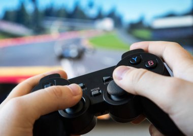 TV 'de yarış oyununu oynayan adam. gamepad denetleyicisi ellerde.