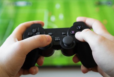 TV 'de futbol oyununu oynayan adam. gamepad denetleyici ellerde.