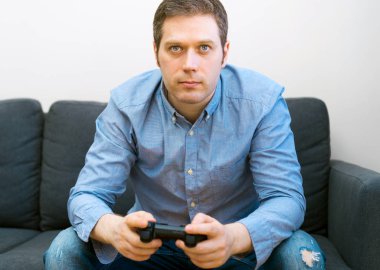Adam el gamepad ile video oyunu oynuyor.