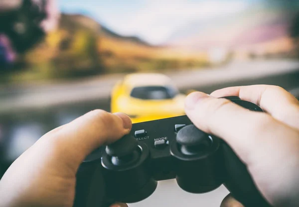 Hombre jugando carreras de videojuegos en la televisión. Gamepad controlador en las manos . — Foto de Stock