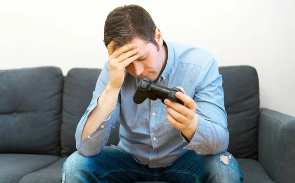 Homem triste com gamepad em mãos jogando videogame . — Fotografia de Stock