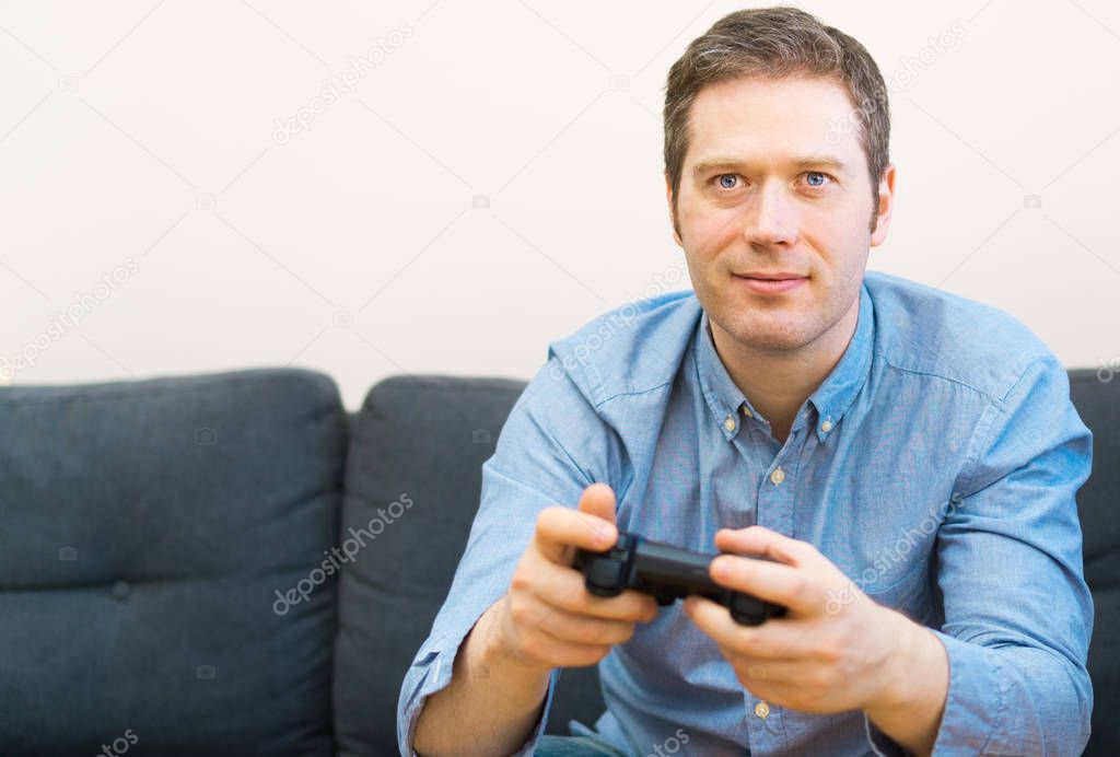 Man playing video game with gamepad in hands.