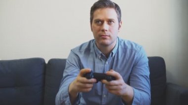 TV 'de atıcı video oyunu oynayan adam. el gamepad denetleyici.