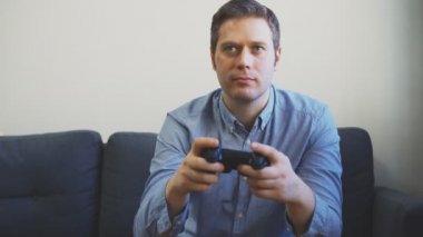 TV 'de yarış oyununu oynayan adam. gamepad denetleyicisi ellerde.