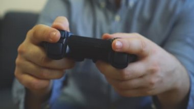 TV 'de yarış oyununu oynayan adam. gamepad denetleyicisi ellerde.