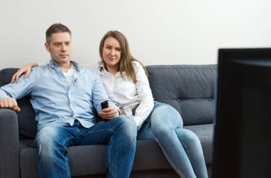 Erkek ve kadın evde Tv izlerken.