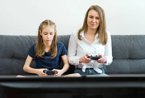 Matka a její roztomilá dcera hrají doma videohru. — Stock fotografie