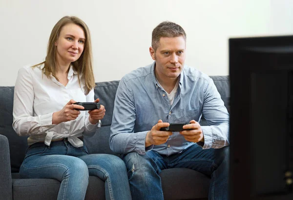 Hombre y mujer jugando videojuegos en casa . — Foto de Stock