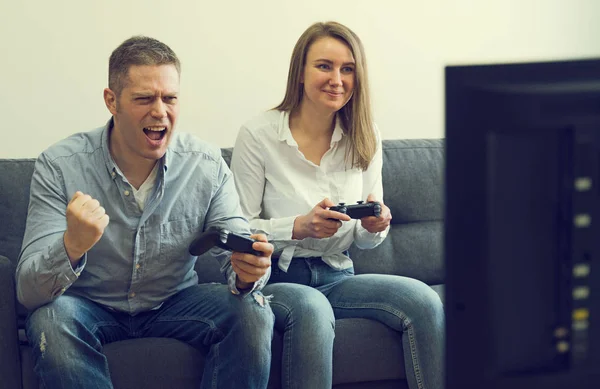 Homem e mulher jogando videogame em casa . — Fotografia de Stock
