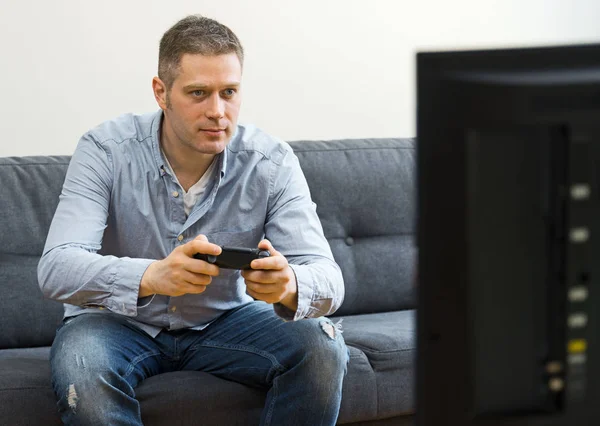 Schöner Mann spielt Videospiel zu Hause. — Stockfoto