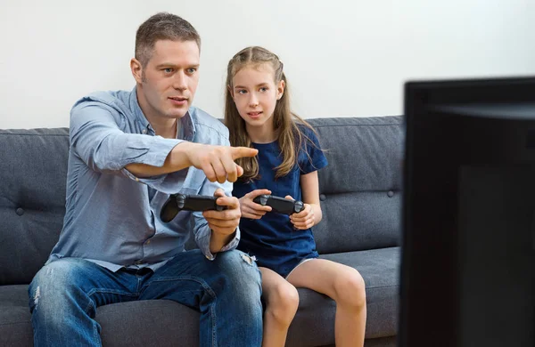 Padre e figlia che giocano ai videogiochi a casa . — Foto Stock