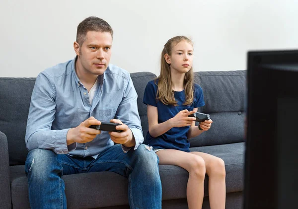 Padre e figlia che giocano ai videogiochi a casa . — Foto Stock