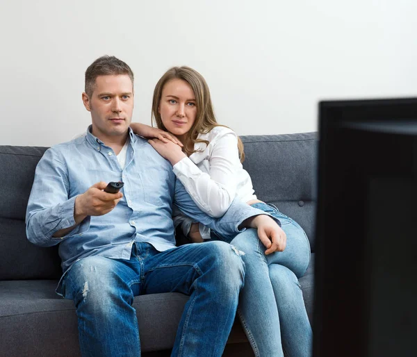 Мужчина и женщина смотрят телевизор дома . — стоковое фото