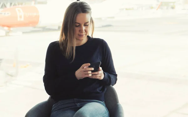 Jeune femme avec téléphone portable à l'aéroport . — Photo