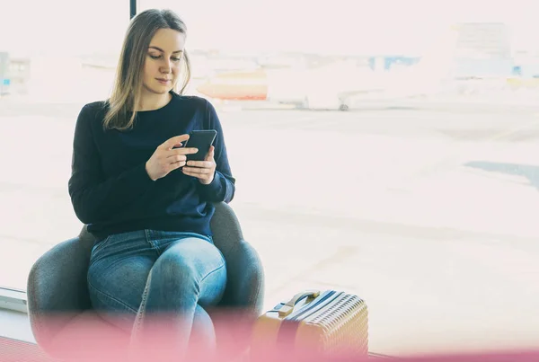 Young woman with mobile phone in the airport. — Stock Photo, Image
