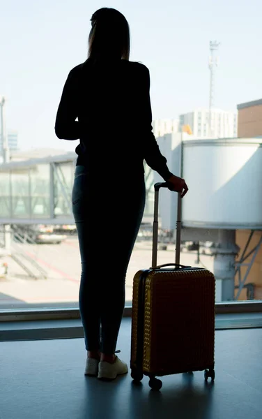 Junge Frau mit Gepäck im Flughafen. — Stockfoto