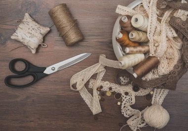 Dikiş konsepti. Makas, iplik makaraları, düğmeler ve dikiş iğneleri.