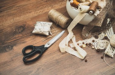 Dikiş konsepti. Makas, iplik makaraları, düğmeler ve dikiş iğneleri.