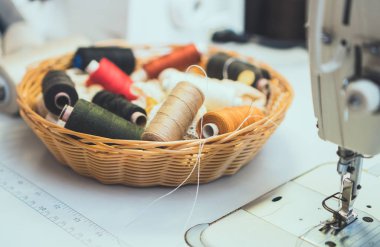 Dikiş konsepti. Dikiş makinesinin yanında çok sayıda iplik bobini.