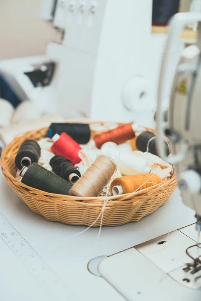 Concept de couture. Beaucoup de bobines de fil à côté de la machine à coudre . — Photo