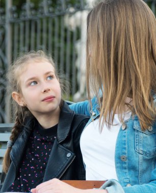 Anne ve kızı bir parkbankında oturuyorlar ve konuşuyorlar..