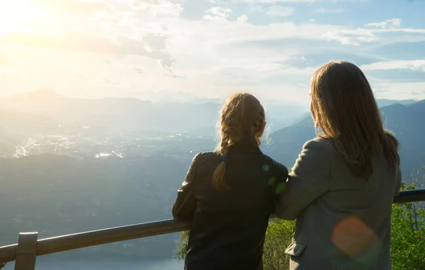 Frau und Tochter genießen Sonnenaufgang vom Gipfel des Berges. — Stockfoto