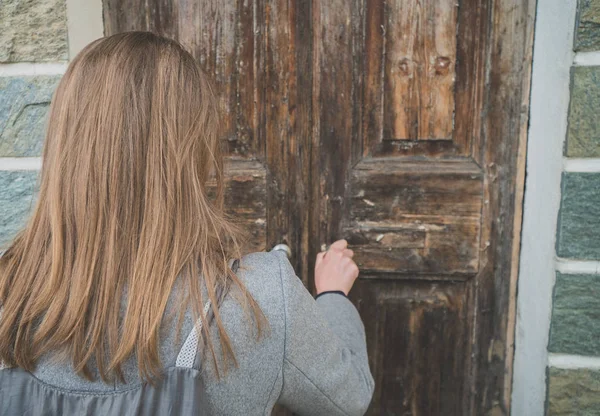 Frau öffnet sehr alte Holztür. — Stockfoto