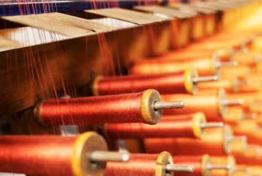 Bir dikiş fabrikasında birçok çok renkli dikiş makaraları.
