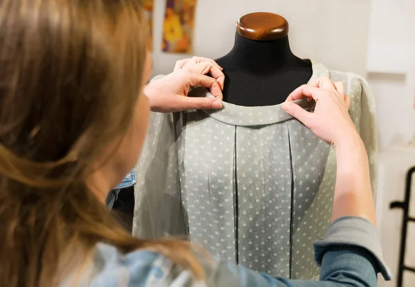 Female designer working with new model tailoring dress on mannequin in atelier. — Stock Photo, Image
