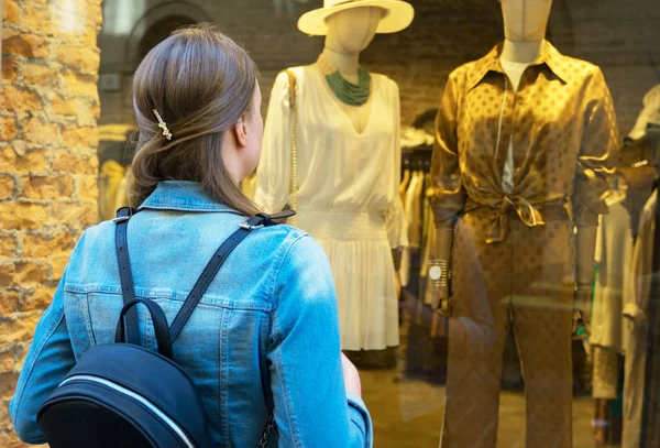 Vrouwelijke toerist kijken naar de etalage van kledingwinkel. — Stockfoto