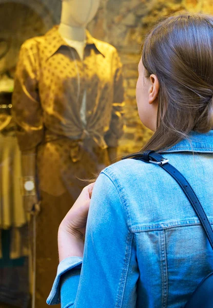 Vrouwelijke toerist kijken naar de etalage van kledingwinkel. — Stockfoto
