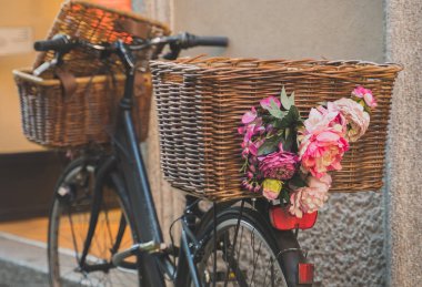 Duvara park edilmiş sepetli retro bisiklet.