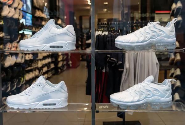 Colección de zapatillas de moda en el escaparate de la tienda de deportes . — Foto de Stock