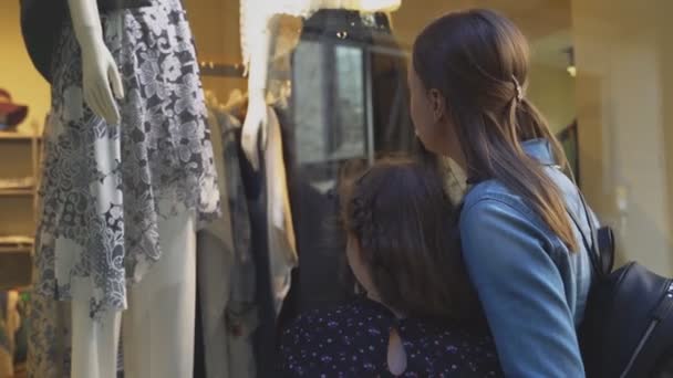 Familie kijken naar winkel venster van kledingwinkel. — Stockvideo