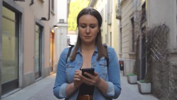 Female tourist in the old city with mobile phone. — Stock Video