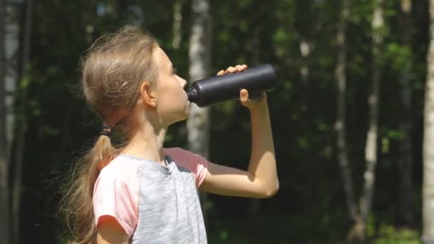Klein meisje in sportkleding drinkwater na de sport. — Stockvideo