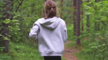 Ormanda koşan küçük bir kız. Spor konsepti.