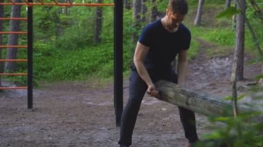 Adam ormanda kütüğü kaldırıyor. Spor konsepti.