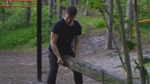 Man Lifting log in het bos. Sport concept. — Stockvideo