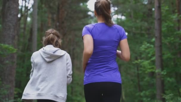 Moeder en dochter lopen in het bos. — Stockvideo