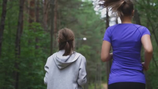 Mutter und Tochter rennen im Wald. — Stockvideo