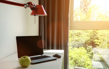 Bir otel odasında masanın üzerinde duran kişisel bilgisayar.