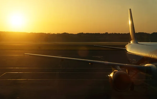 Onderdeel van het vliegtuig op de landingsbaan bij zonsondergang. — Stockfoto